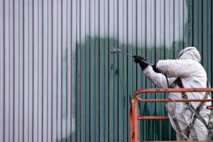 commercial painter on a lift spraying paint