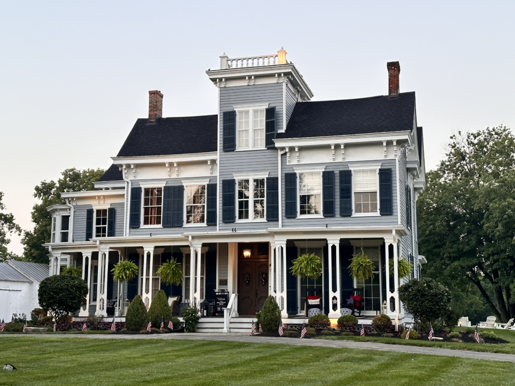 a freshly painted historic victorian house with blue shutters and white trim